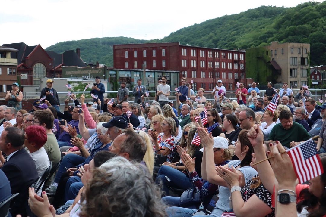 Crowd waves American flags at a rally