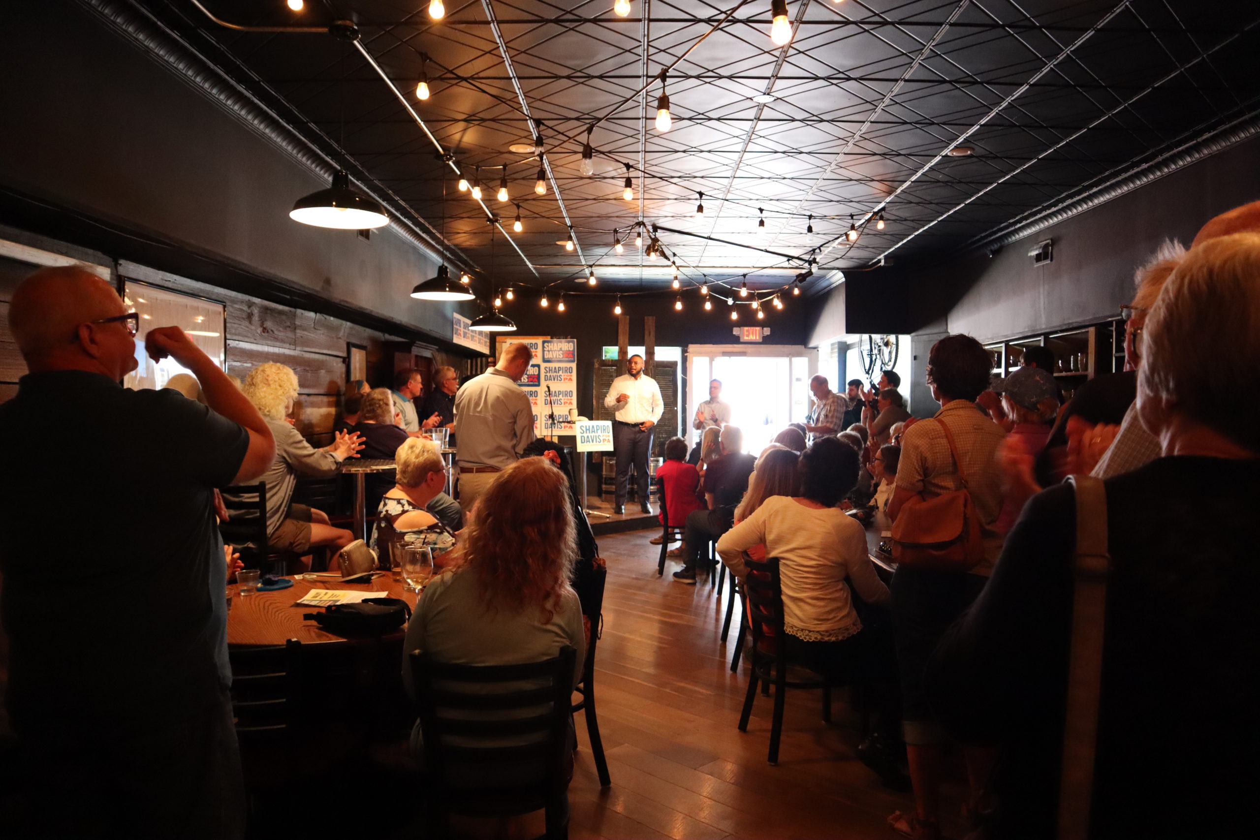 Austin Davis stands at the front of a room filled with supporters