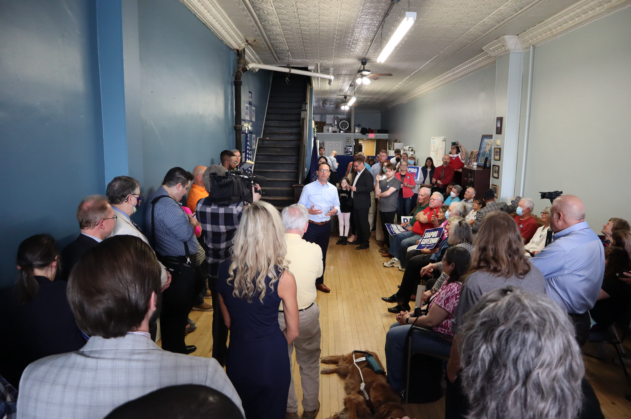 Josh speaking to a crowded room of supporters.