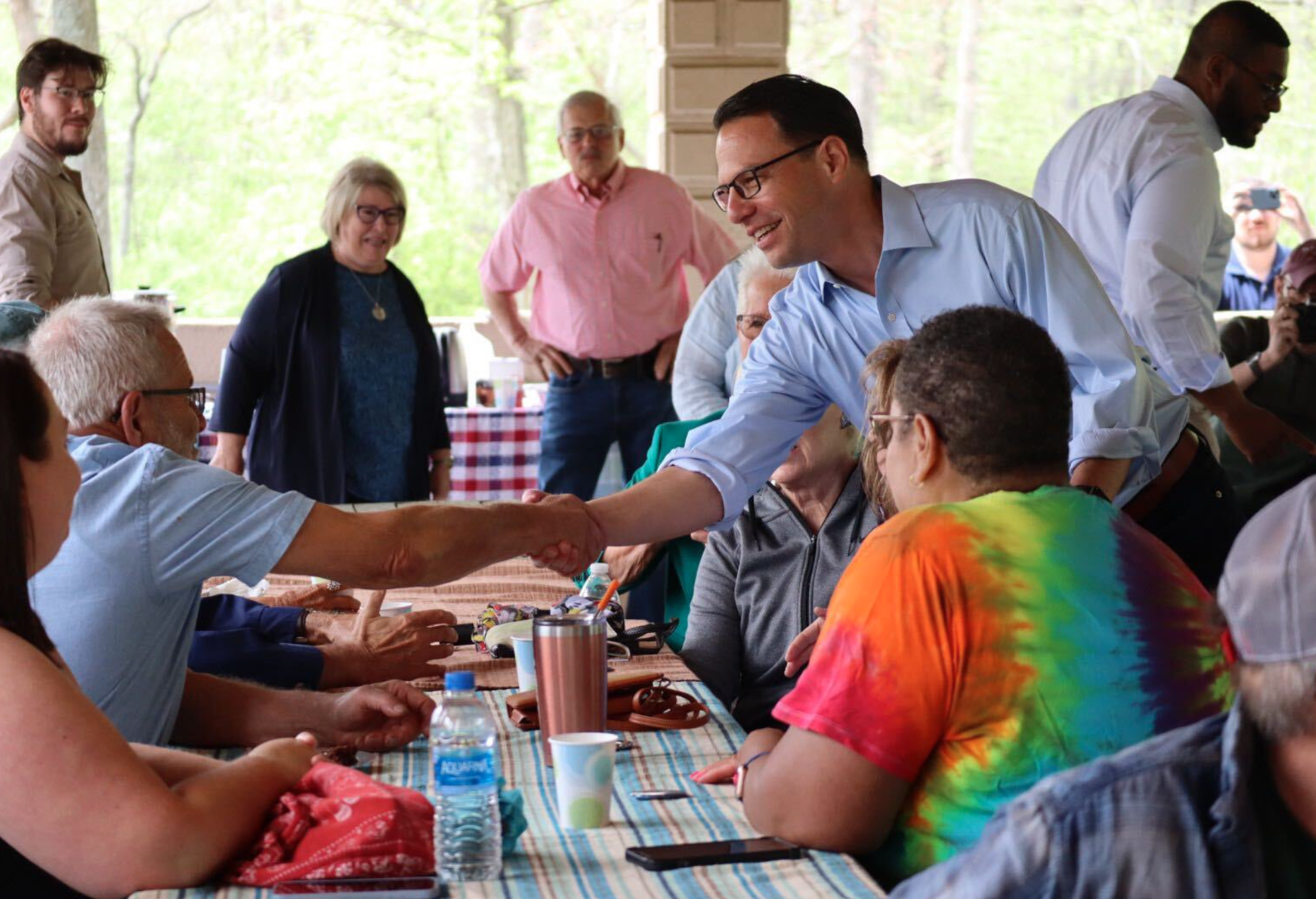 Josh shakes hands with a man at a picnic.