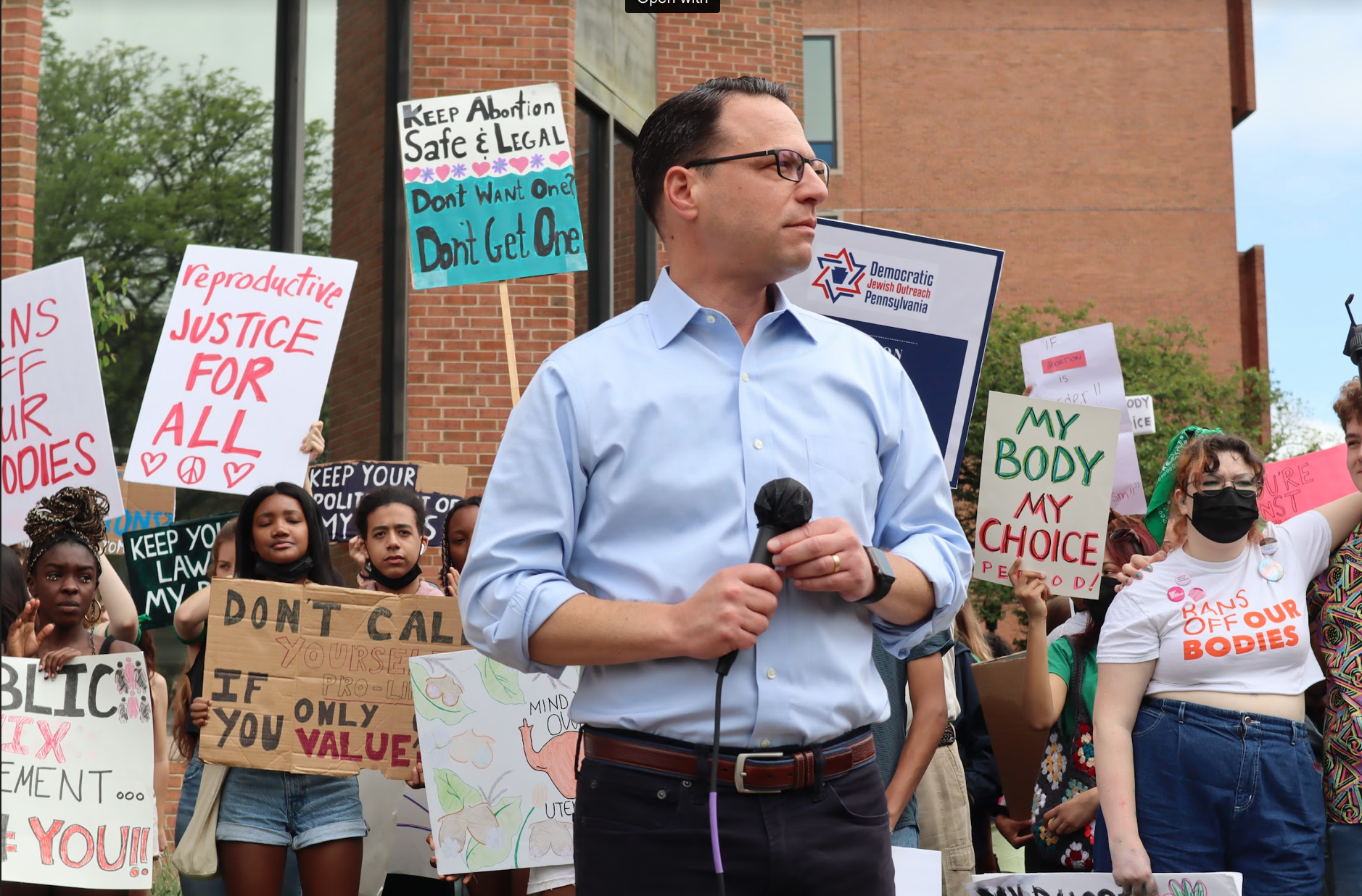 Josh holds a microphone at a pro-choice rally.